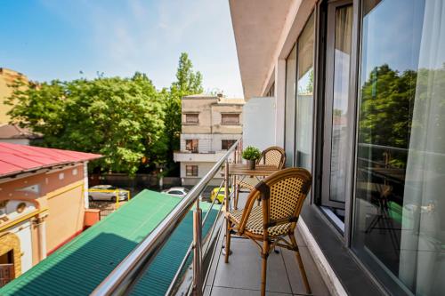 a balcony with a table and two chairs on it at Urban Elegance - Stylish Central Accommodation in Bucharest