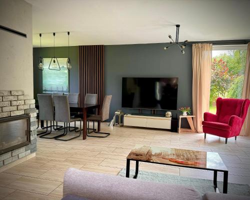 a living room with a television and a table and chairs at Cicha Ostoja in Miłków