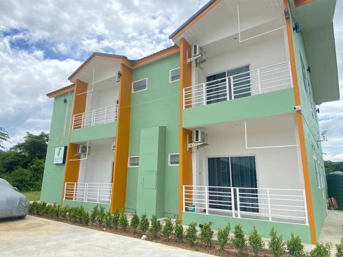 a building with green and orange at Dino Homestay in Ban Muang Chum