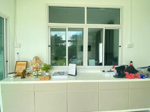 a white counter with a window in a room at Dino Homestay in Ban Muang Chum