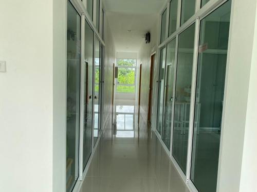 a hallway with glass doors at Dino Homestay in Ban Muang Chum