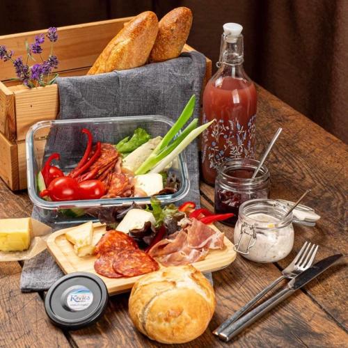a table with a tray of food and a container of bread at Völgy Villa in Zebegény