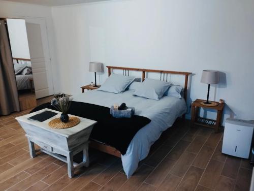 une chambre avec un grand lit et une table dans l'établissement Maison de campagne idéale pour les retrouvailles en famille, à Varaignes