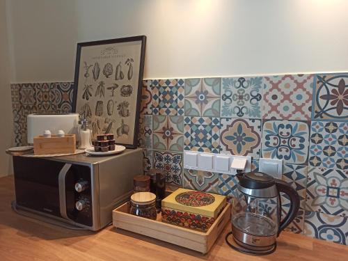 a kitchen with a microwave on a counter and a wall at Apartament przy Wandy in Zielona Góra