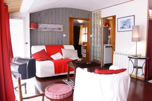 a bedroom with a red and white bed and a table at Charmante Péniche - Séjour atypique Nantes in Nantes