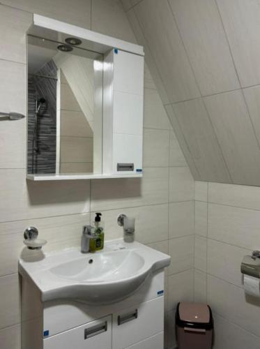 a bathroom with a white sink and a mirror at Apartmani Gocki Raj 2024 Vrnjačka Banja in Vrnjačka Banja