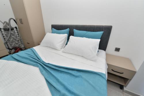 a bed with blue and white sheets and pillows at Ethica Suite Luxury Houses in Aksu