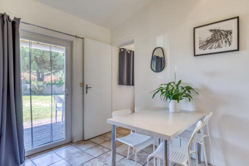 a dining room with a table and chairs and a window at Mas des Cypres - Mazet 7 in Saintes-Maries-de-la-Mer