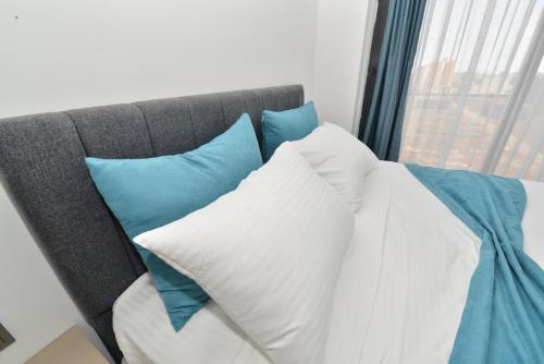 a pile of pillows sitting on a couch with a window at Ethica Suite Luxury Houses in Aksu