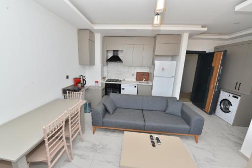 a living room with a couch and a kitchen at Ethica Suite Luxury Houses in Aksu