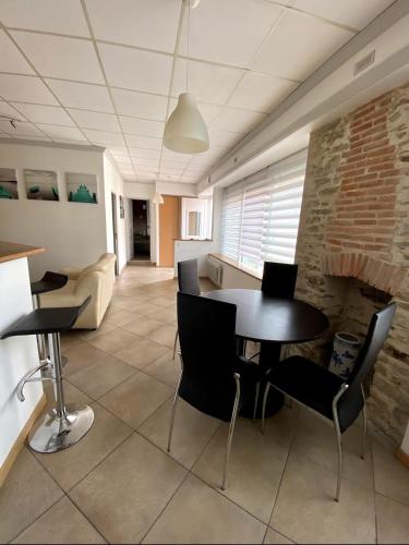 une pièce avec une table et des chaises et un mur de briques dans l'établissement La source, à Pornic