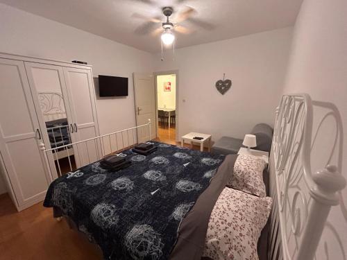Un dormitorio con una cama y un televisor. en Rosa Apartments, en Ist