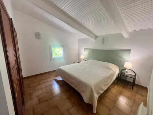 une chambre avec un grand lit blanc et une fenêtre dans l'établissement Bastide provençale familiale, grande piscine, prés d'Aix en pleine nature, à Bouc-Bel-Air