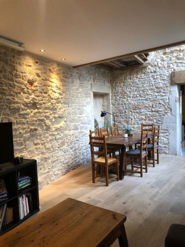 une salle à manger avec une table en bois et un mur en pierre dans l'établissement Maison Millot, à Beaune