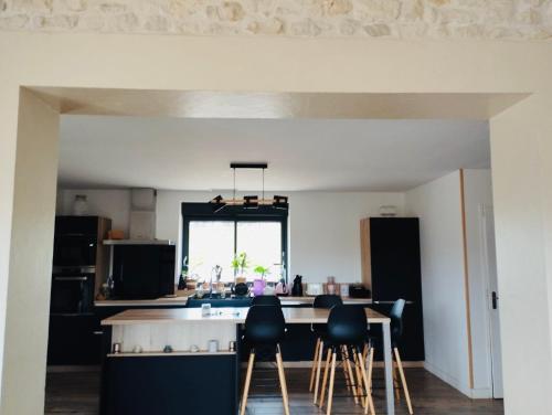 une cuisine avec une table et quelques chaises dans l'établissement Maison de campagne idéale pour les retrouvailles en famille, à Varaignes