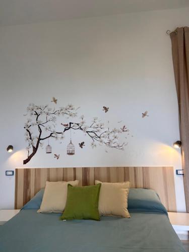a bedroom with a bed with a tree with birds on it at Donna Linda in Perdifumo