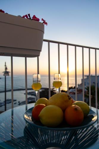 a bowl of fruit and two glasses of wine on a table at FICO D'INDIA in Peschici