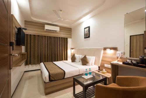 a hotel room with a bed and a table at Hotel Avon Ruby Dadar in Mumbai