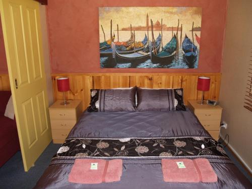 a bedroom with a bed with a painting on the wall at Launceston Holiday Park Legana in Legana