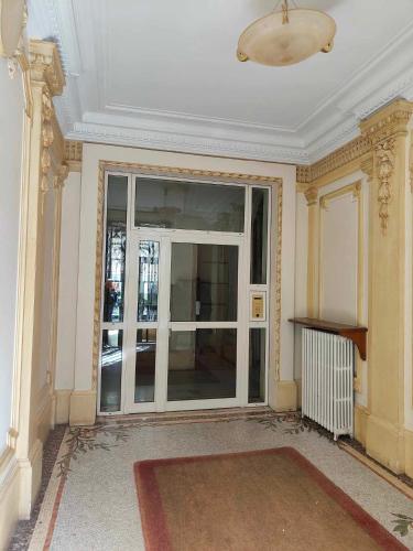 une pièce vide avec une grande porte en verre dans un bâtiment dans l'établissement Studio cosy 17e Arc de Triomphe et champs Élysées, à Paris
