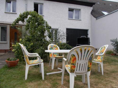 three chairs and a table in front of a house at Ferienwohnung in Usedom Town
