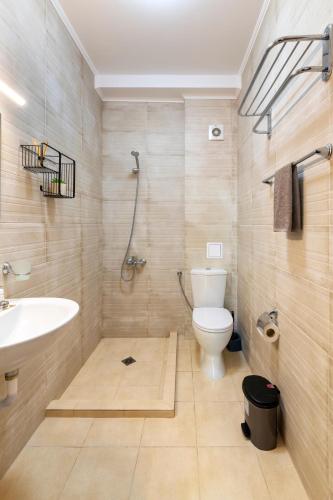 a bathroom with a shower and a toilet and a sink at IRB Guest House Emona 4 in Nesebar