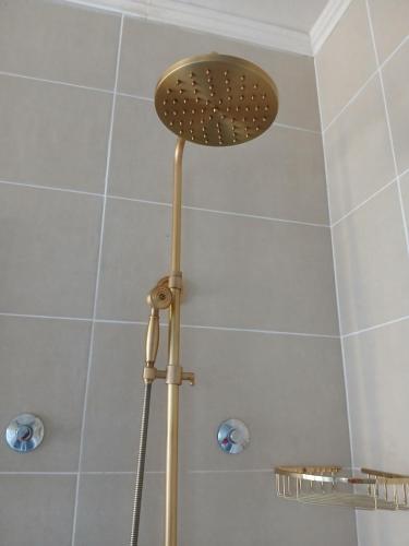 a shower with a shower head in a bathroom at Provence rooms in Banja Luka