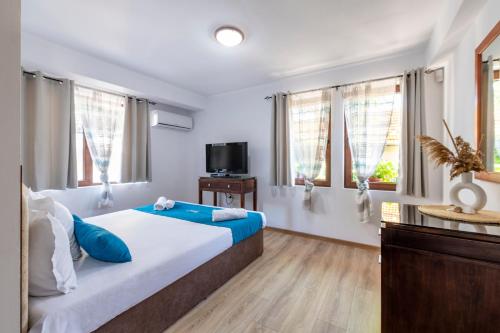 a bedroom with a large bed with blue pillows at IRB Guest House Emona 4 in Nesebar