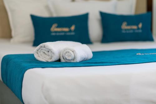 a stack of towels on a bed with blue pillows at IRB Guest House Emona 4 in Nesebar
