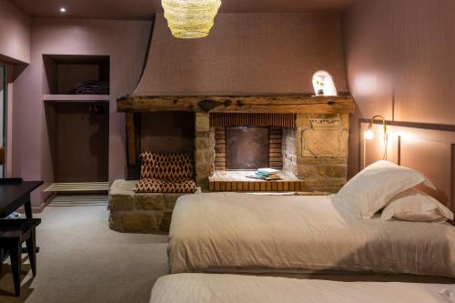 - une chambre avec une cheminée, un lit et une chaise dans l'établissement Domaine La Gentilhommière, à Satillieu
