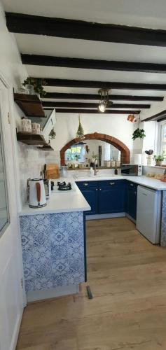 a kitchen with blue and white tiles on the counters at Beatrice Cottage in Richmond