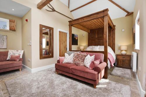 a bedroom with a bed and a couch and a bed at The Chestnuts Country House Boutique B&B in Kilvington
