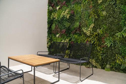 two chairs and a table in front of a green wall at The Republic Boutique Hotel in Valletta