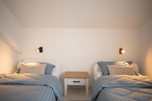 a room with two beds and a table between them at Apartmani Link in Požega