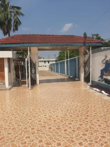 a building with a dirt road in front of it at Lincoln Prestige Hotel in Accra