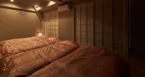长崎おやど紀伊国屋銀屋町弐館的一间位于黑暗客房内的卧室