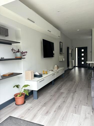 a large living room with white walls and wooden floors at Luxury modern apartment with free private parking in Saint Albans