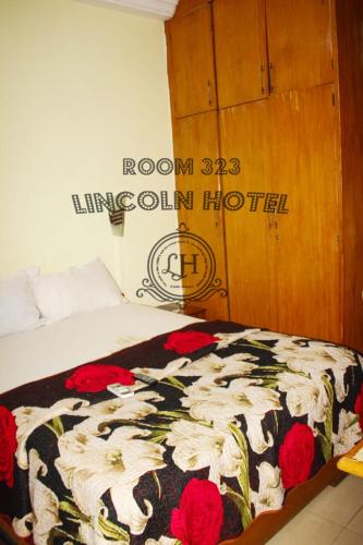 a bedroom with a bed with a floral blanket at Lincoln Prestige Hotel in Accra