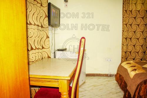 a small table in a room with a bed at Lincoln Prestige Hotel in Accra