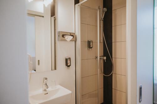 a bathroom with a sink and a shower at Boutiquehotel Stadthalle in Vienna