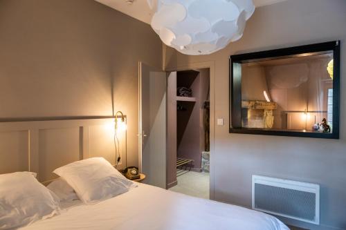 a bedroom with a bed with a mirror on the wall at Domaine La Gentilhommière in Satillieu