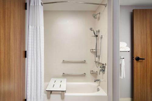 a white bathroom with a tub and a shower at Hyatt Place Melbourne Airport, Fl in Melbourne
