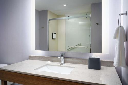 a bathroom with a sink and a large mirror at Hyatt Place Melbourne Airport, Fl in Melbourne