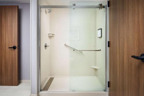 a shower with a glass door in a bathroom at Hyatt Place Melbourne Airport, Fl in Melbourne