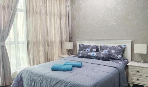 a bedroom with a bed with blue pillows on it at SAFIYA Homestay Vista Alam in Shah Alam