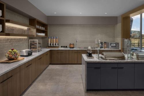 a large kitchen with wooden cabinets and a counter top at Homewood Suites By Hilton Grand Prairie At EpicCentral in Grand Prairie