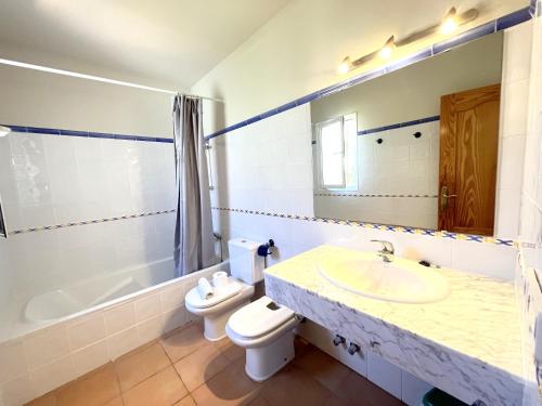 a bathroom with a sink and a toilet and a tub at Villas Monte Jávea - BTB in Jávea