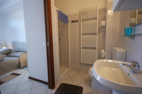 Un baño con lavabo, inodoro y un sofá. en Manzoni, en Stresa