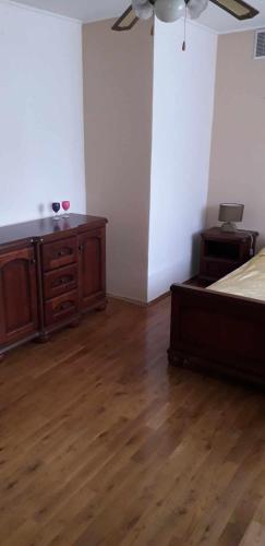 a bedroom with a bed and a dresser and a fan at Zajazd Stok in Górecko Stare