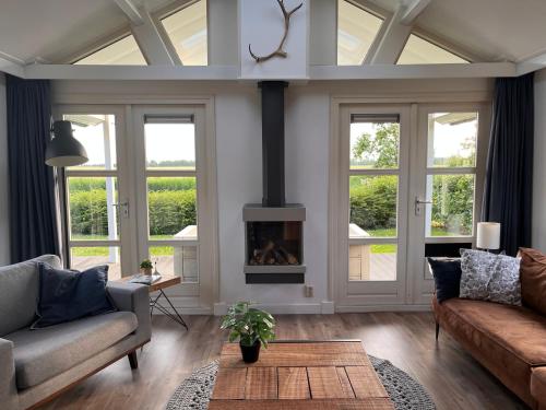 a living room with a couch and a fireplace at Beau34 in Kattendijke